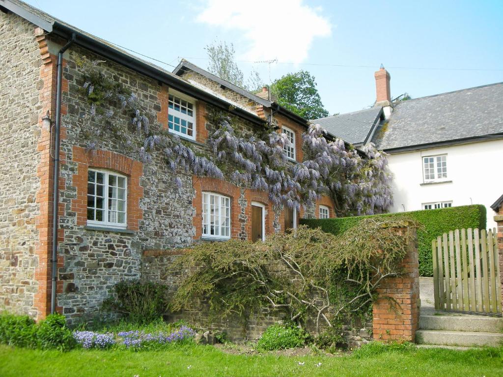 an old brick house with a ivy growing on it at Cider Cottage - E5576 in Warkleigh