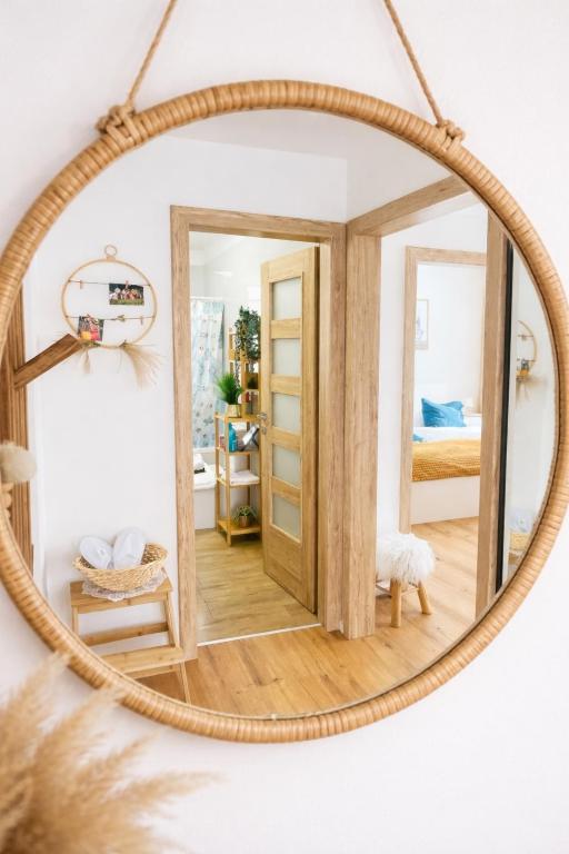 a round mirror hanging on a wall in a bedroom at Labela Luhačovice Apartment in Luhačovice