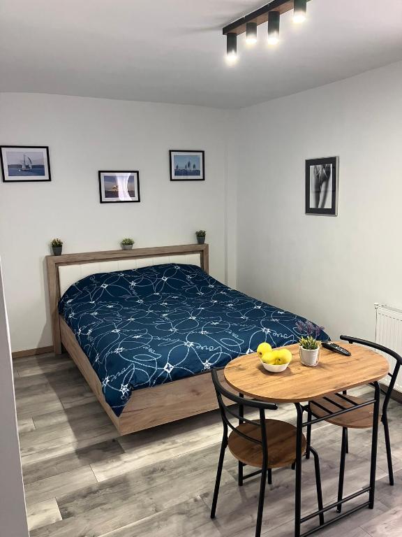 a bedroom with a bed and a table with chairs at Garsoniera Goldis in Arad