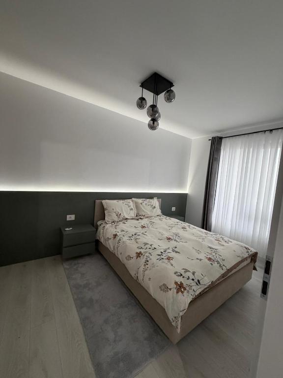 a bedroom with a bed and a white wall at Deluxe 3 in Timişoara