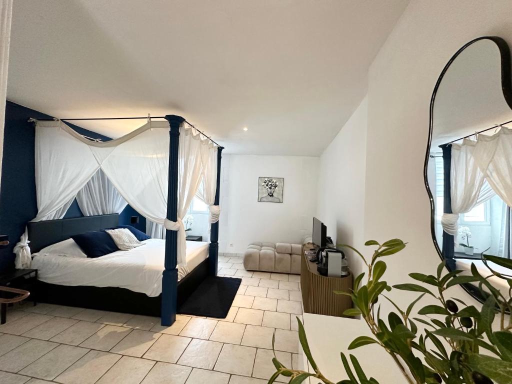 a bedroom with a canopy bed and a mirror at Nuit En Brenne in Le Blanc