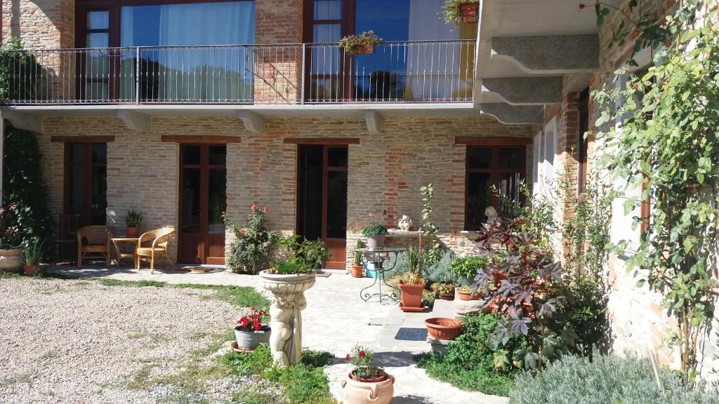 une cour avec des plantes en pot devant un bâtiment dans l'établissement Agriturismo ErcolAna, à Neviglie