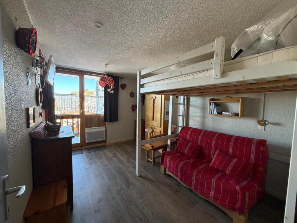 a living room with a red couch and a loft bed at Studio La Plagne Villages in La Plagne Tarentaise