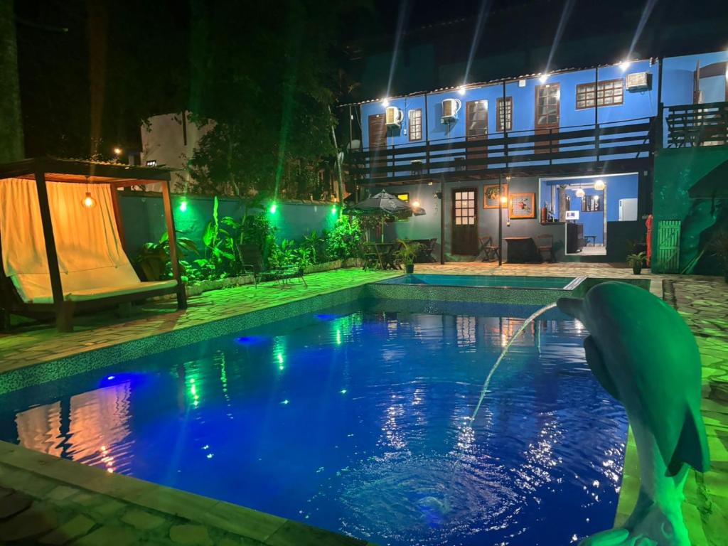 a swimming pool at night with a dolphin in the water at POUSADA BELLA SPIAGGIA in Paraty