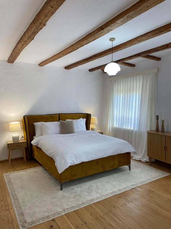 a bedroom with a large bed and a window at Doftana 609 in Trăisteni