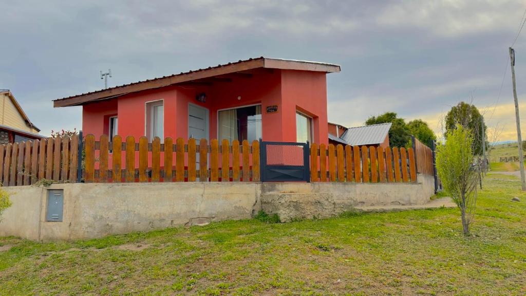 a red house with a fence in front of it at Buena Vista Trevelin II in Trevelín