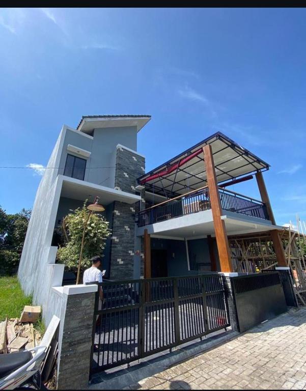 a man standing in front of a house at Villa Oentoeng 1 Private Pool 3 Kamar in Punten