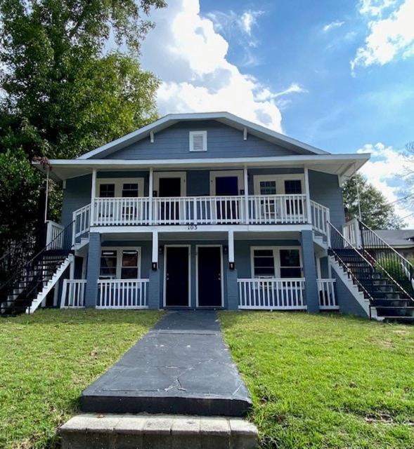 a large blue house with a porch and stairs at Skipper Apt 1 in Rockingham