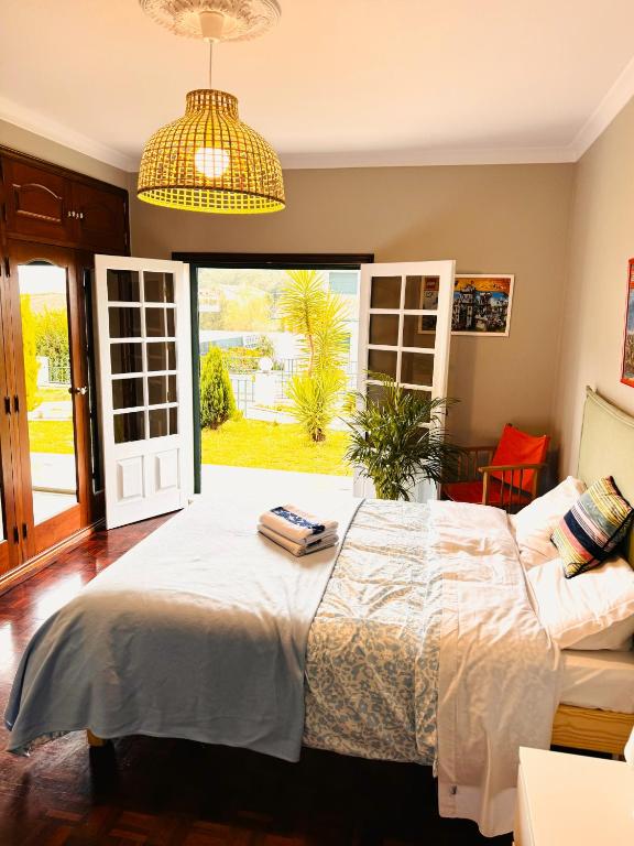 a bedroom with a bed and a large window at LEIRIA Side in Leiria