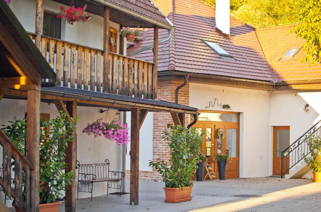 a house with a balcony with flowers on it at Farma Zelená Ruža in Kľačno
