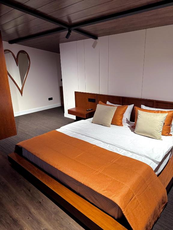 a bedroom with a large bed with an orange blanket at Château Byurakan Hotel in Byurakan