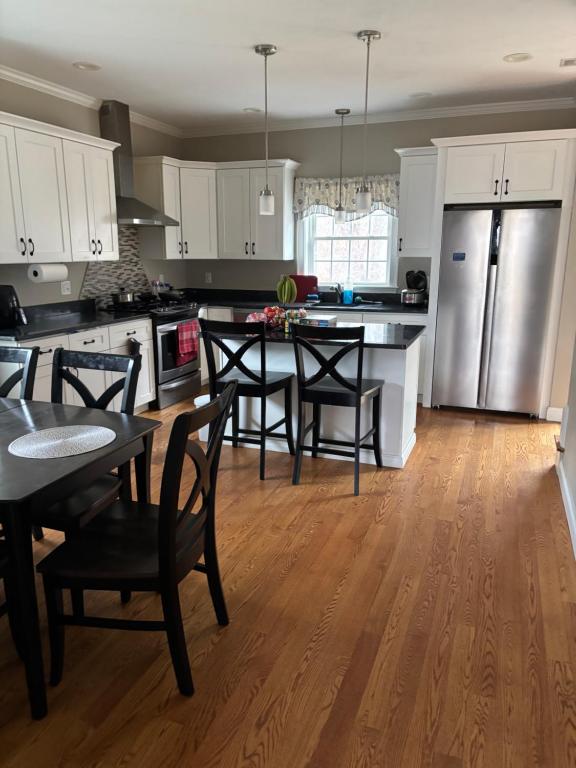 a kitchen with a table and chairs and a refrigerator at 12Birchwood in Holbrook