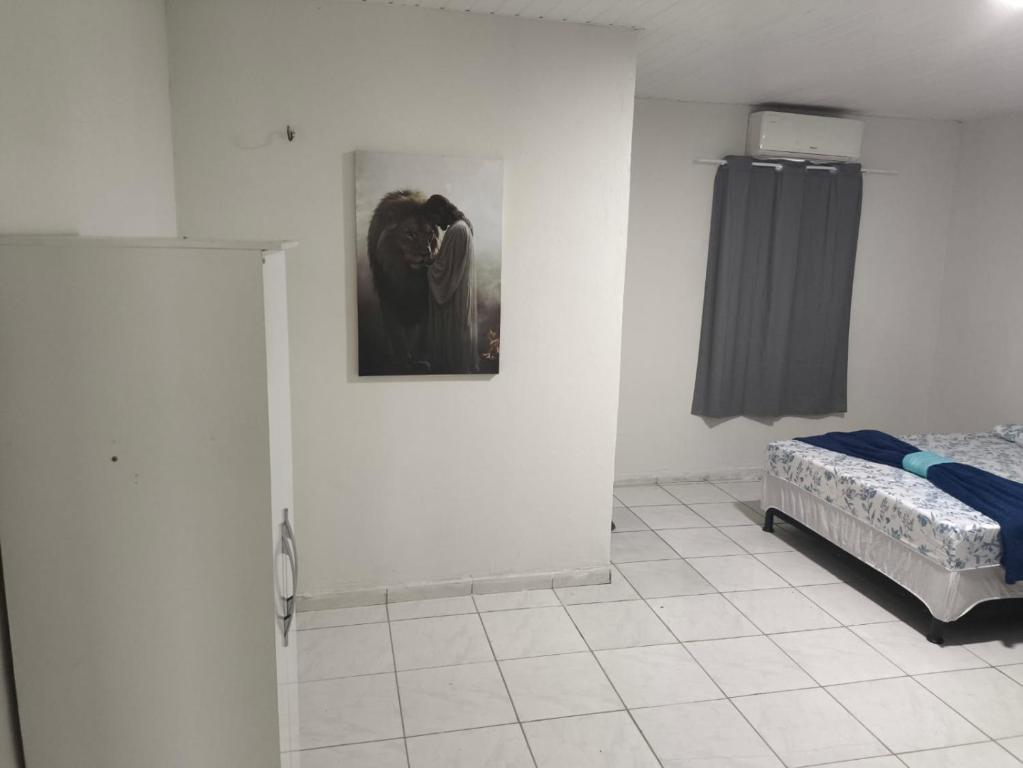 a room with a bed and a picture on the wall at Pousada Ouro branco Mossoró RN in Mossoró