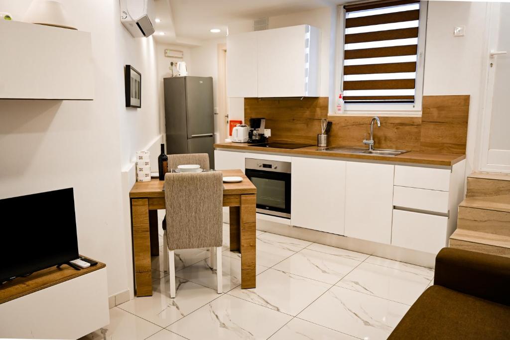 a kitchen with white cabinets and a wooden table at 10 Msida Park Residence in Msida