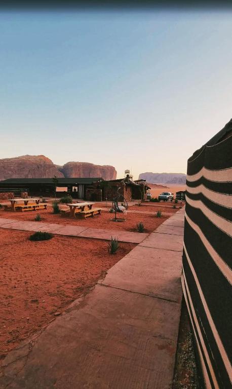 a sidewalk in the middle of a desert with picnic tables at Wadi rum fun time in Wadi Rum