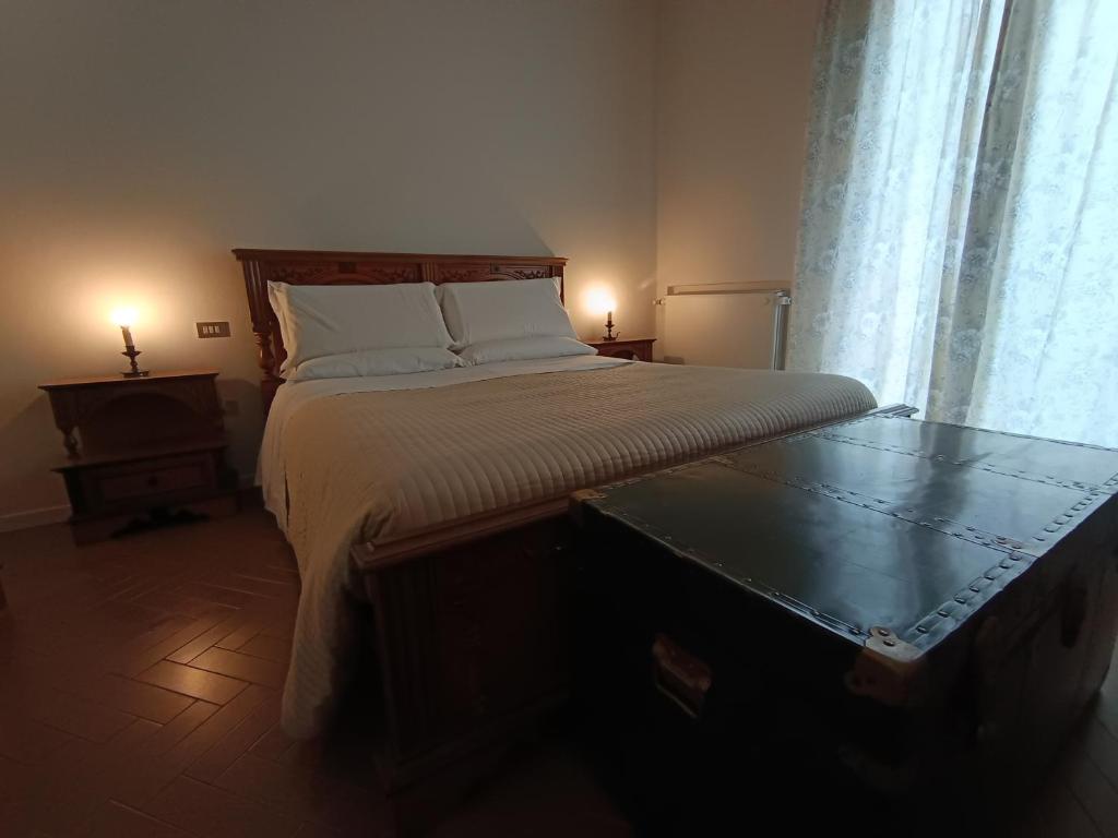 a bedroom with a bed and a table with two lamps at A Casa di Luca in Faenza