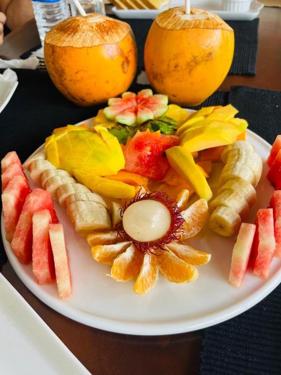 a white plate with fruit on top of a table at Ayana Beach Garden in Negombo
