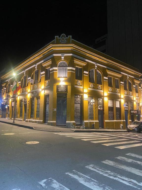 a yellow building on a street at night at Casabella Hotel in Manizales
