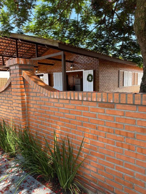 a brick retaining wall in front of a house at Gastehaus Watzko in Piçarras