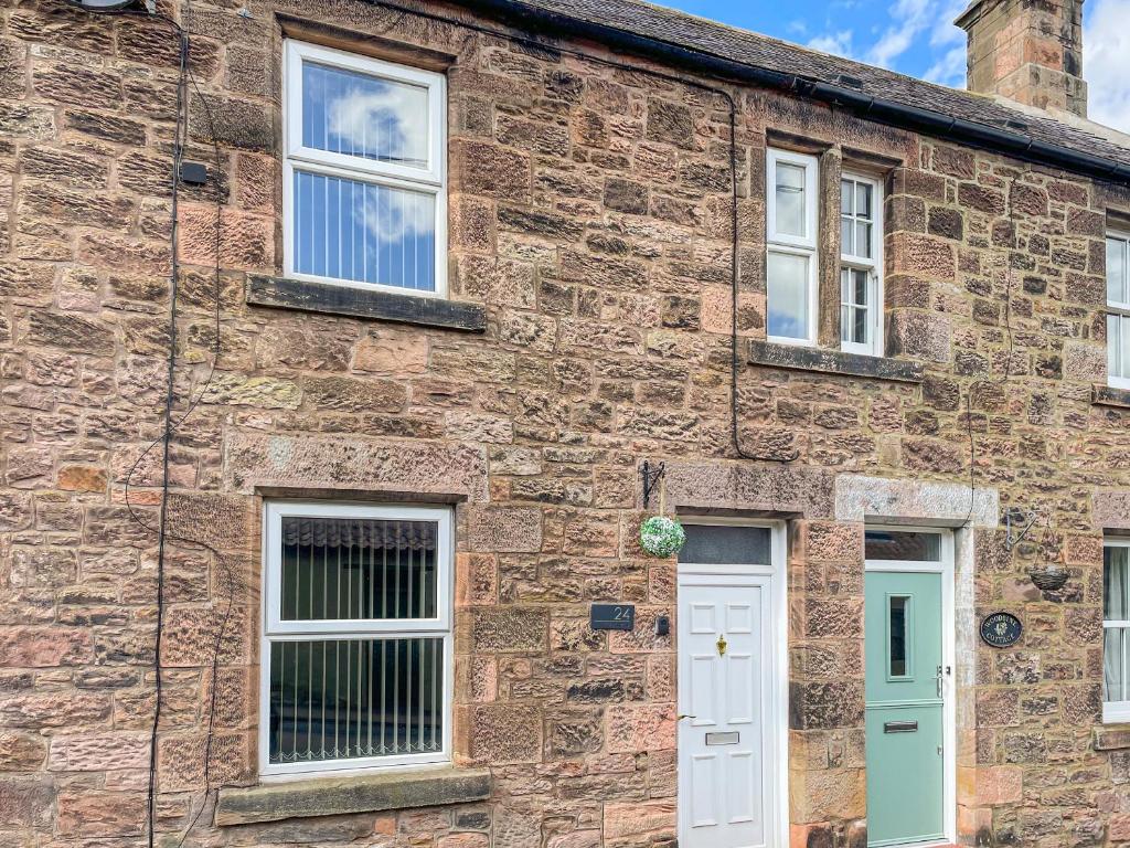 an old brick house with white doors and windows at The Bolt Hole in Wooler