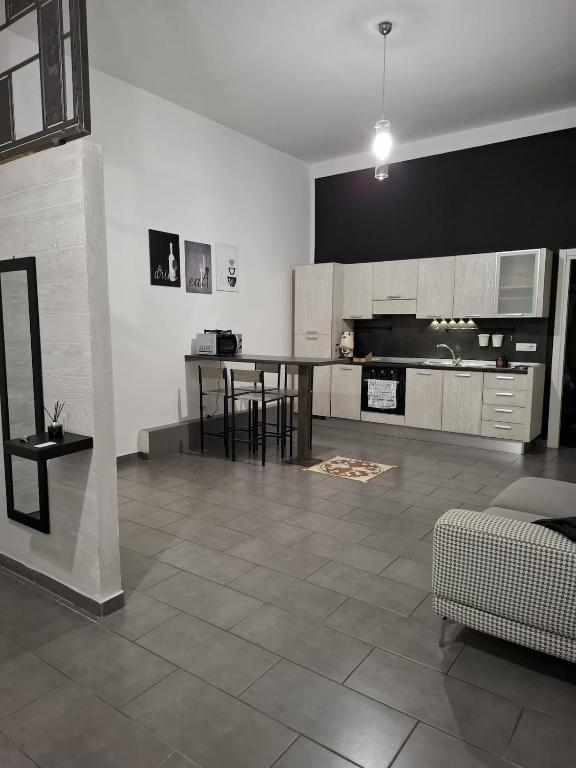 a living room with a kitchen with a table and chairs at Officina dei ricordi in Casagiove