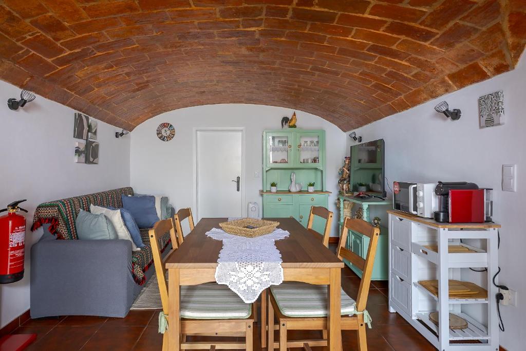 a dining room with a table and chairs and a kitchen at Casita dos Avós in Alandroal