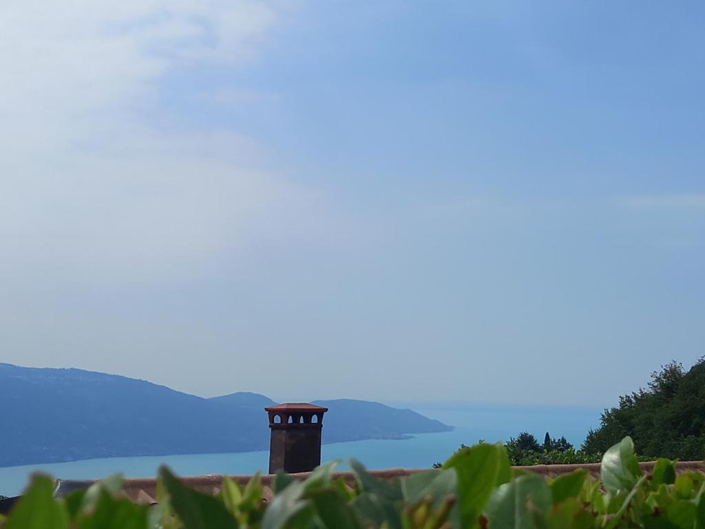 a brick chimney on top of a building with mountains in the background at Sunclass Tignale Bungalow Gardasee in Tignale