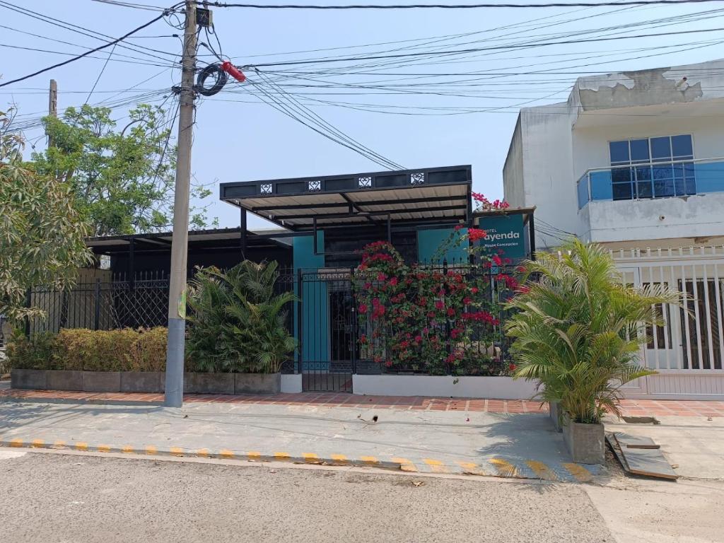 a building with a gate with flowers in front of it at House Concepcion in Estación El Salto