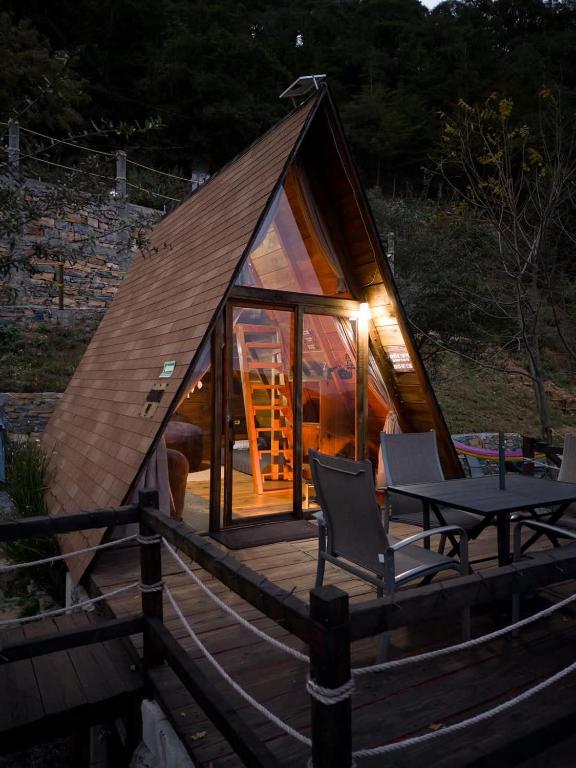 a small cabin with a table and chairs on a deck at DM El Refugio SG B2 in Pinal de Amoles