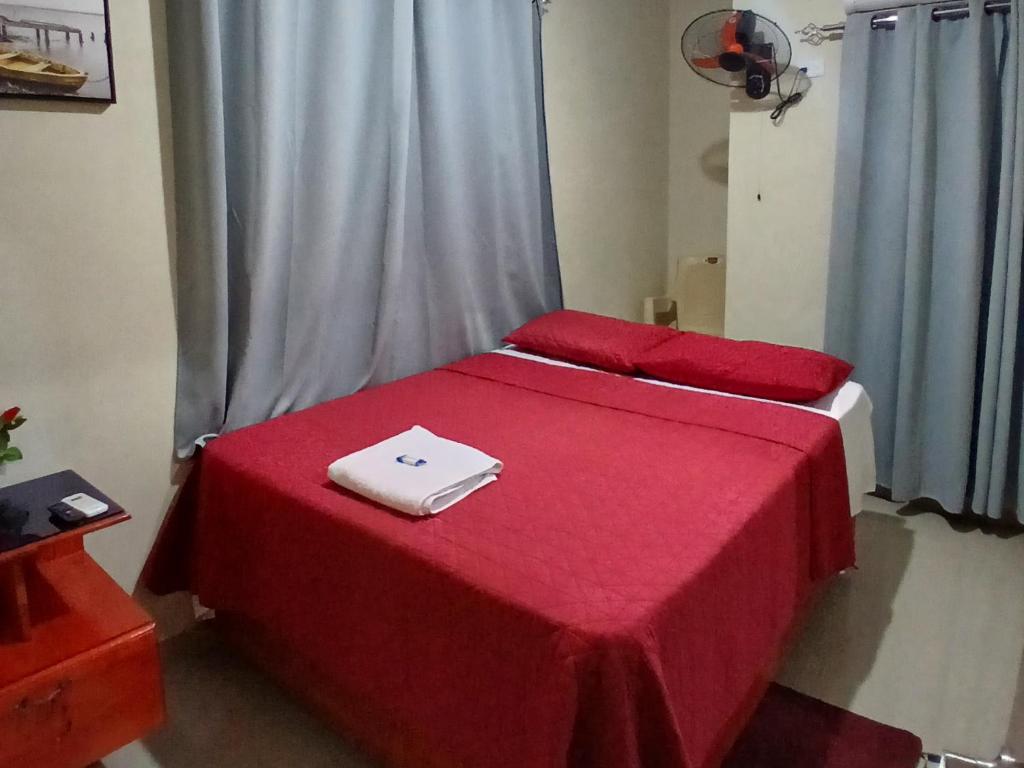 a room with two beds with red sheets and a window at Hotel los 4 Tesoros in Pedernales