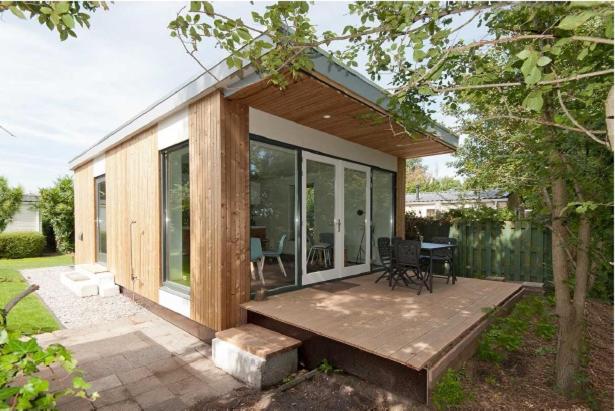 a small house with a deck with a table at Litehomeatseagoedereede in Goedereede