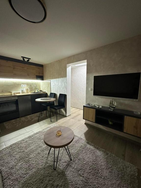 a living room with a flat screen tv and a table at Arni apartments in Donja Vrežina