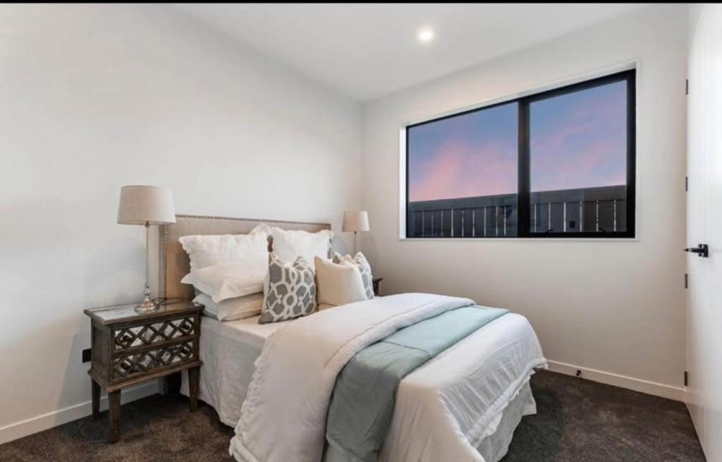 a bedroom with a large bed and a window at Unique Stays in Auckland