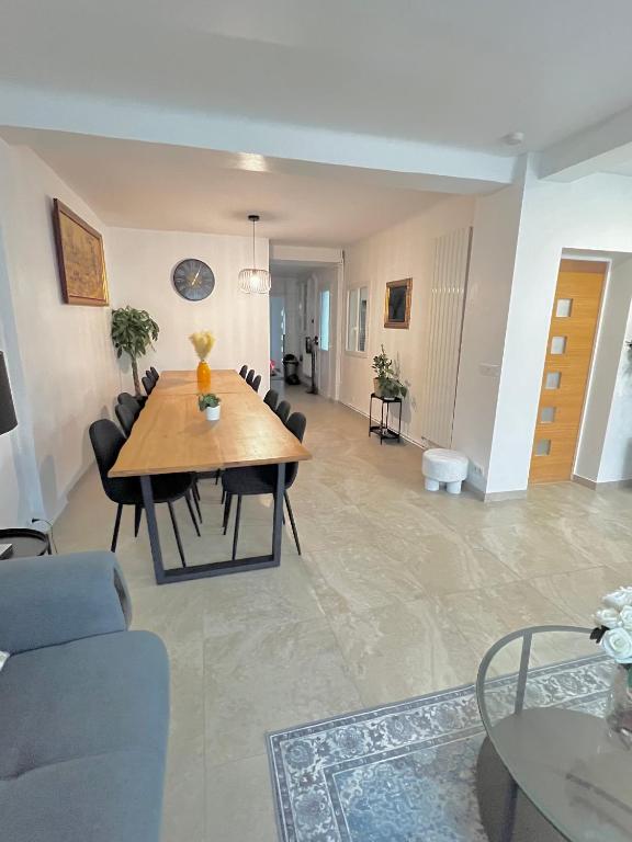 a living room with a wooden table and chairs at Grande Maison XXL in Villiers-le-Bel