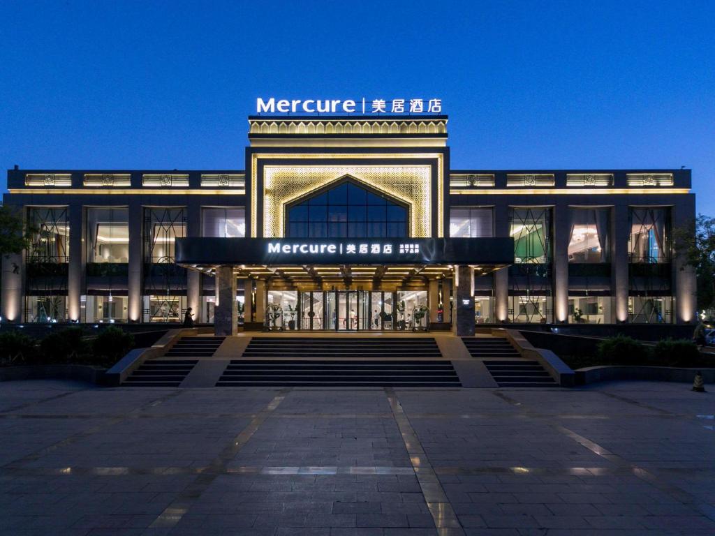 a large building with a sign on the front of it at Mercure Turpan Downtown in Turfan