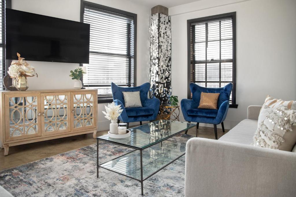 a living room with a tv and blue chairs at Bright lights central Downtown in Los Angeles