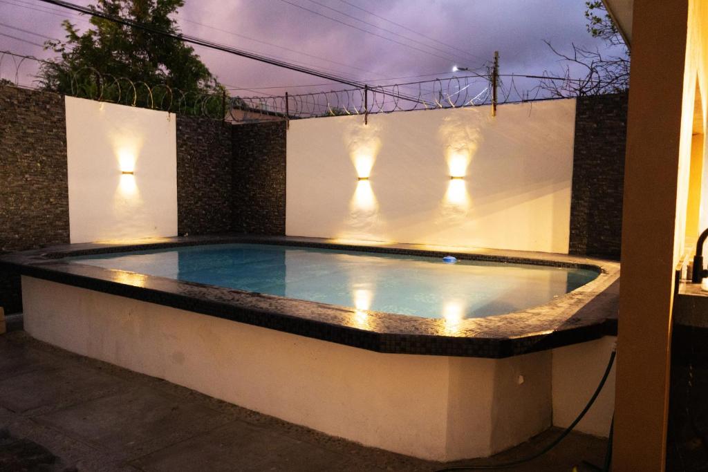a swimming pool with lights in a backyard at night at Residencia G in Champotón