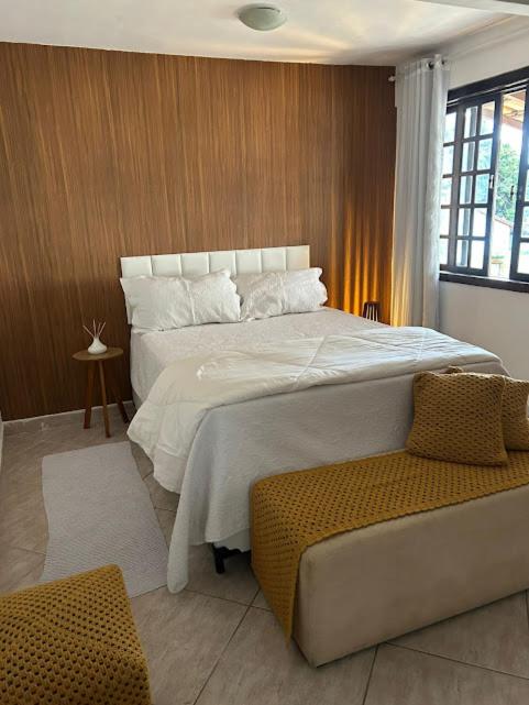 a bedroom with a large bed and a chair at Recanto da barra in Ilha do Bom Jardim