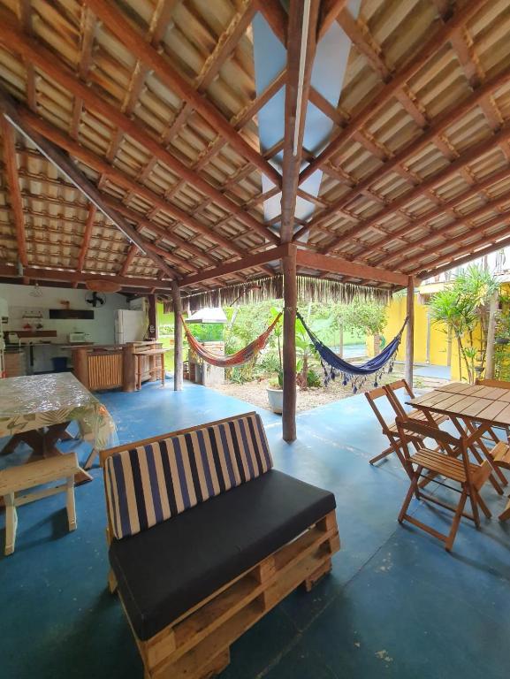 a pavilion with a hammock and a table and chairs at Céu Azul Casa de Praia in São Sebastião