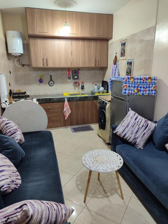 a living room with a couch and a kitchen at Tamazart ait melloul in Ait Melloul