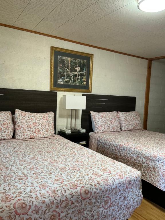 a bedroom with two beds and a picture on the wall at Starlight Motel in Big Pine