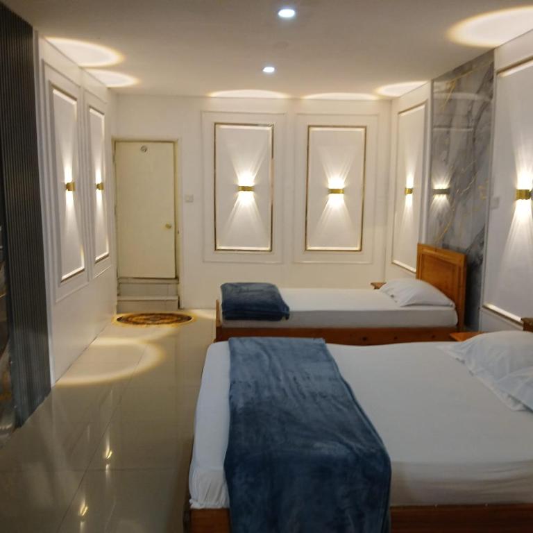 a hotel room with two beds and two lights at Residence Annapurna Indian in Dakar