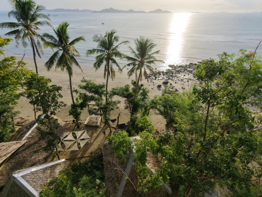 an aerial view of a beach with palm trees at Kamp Tapik - Sibaltan in El Nido