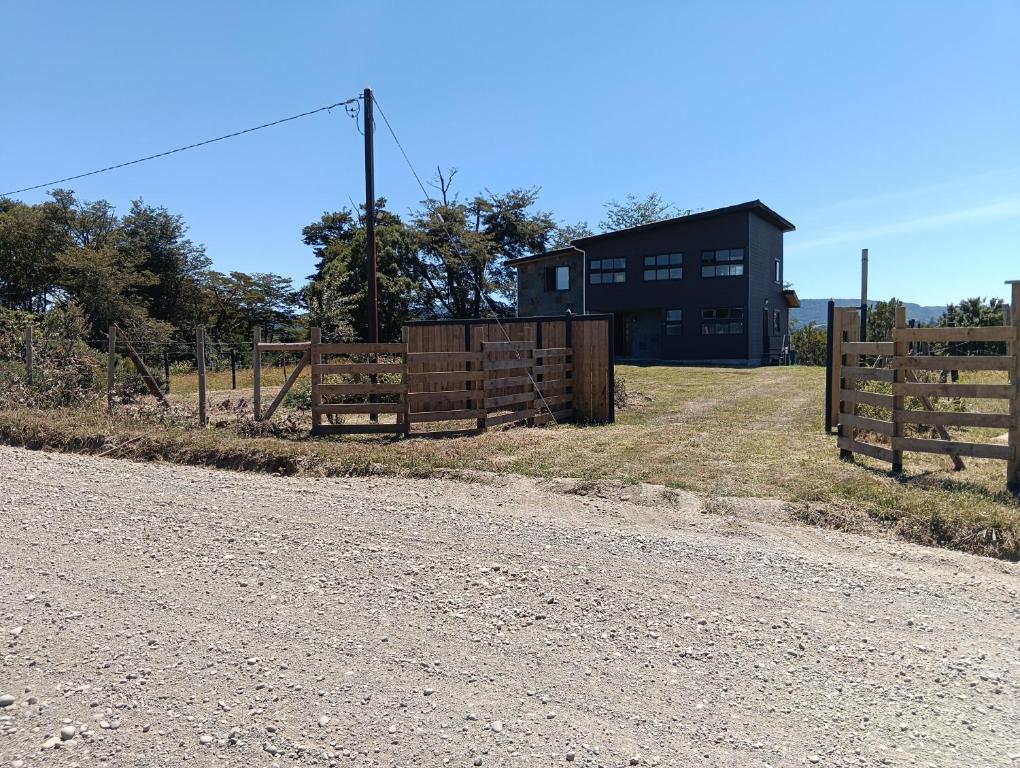 a fence in front of a black building at Lomas de Hullinco Lodge in Petanesí Alto