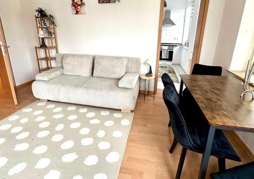 a living room with a white couch and a table at Bright temporary apartment in Schkeuditz in Schkeuditz