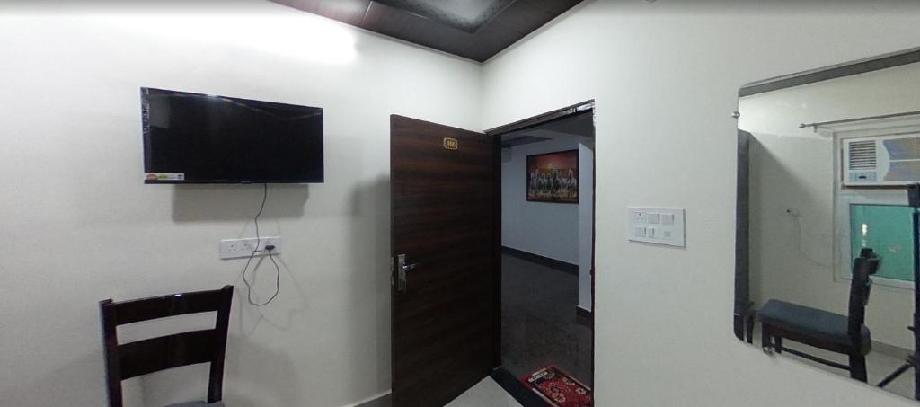 a room with a flat screen tv on a wall at EVERGREEN Inn in Nalmatha