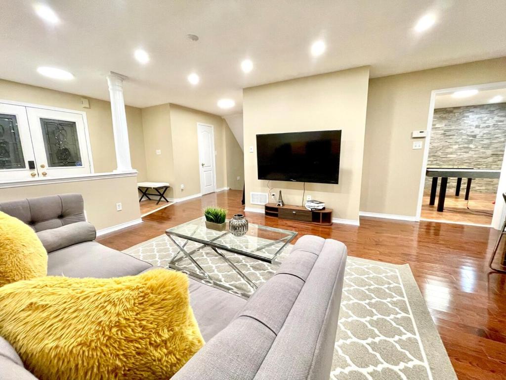 a living room with a couch and a flat screen tv at Paris Charm Modern 4B3B, Kitchen, Parking,5G in Richmond Hill