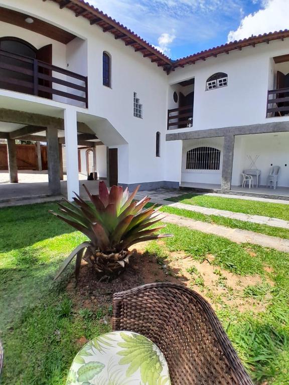 a backyard of a white house with a plant at Mansion in the mountains in Teresópolis