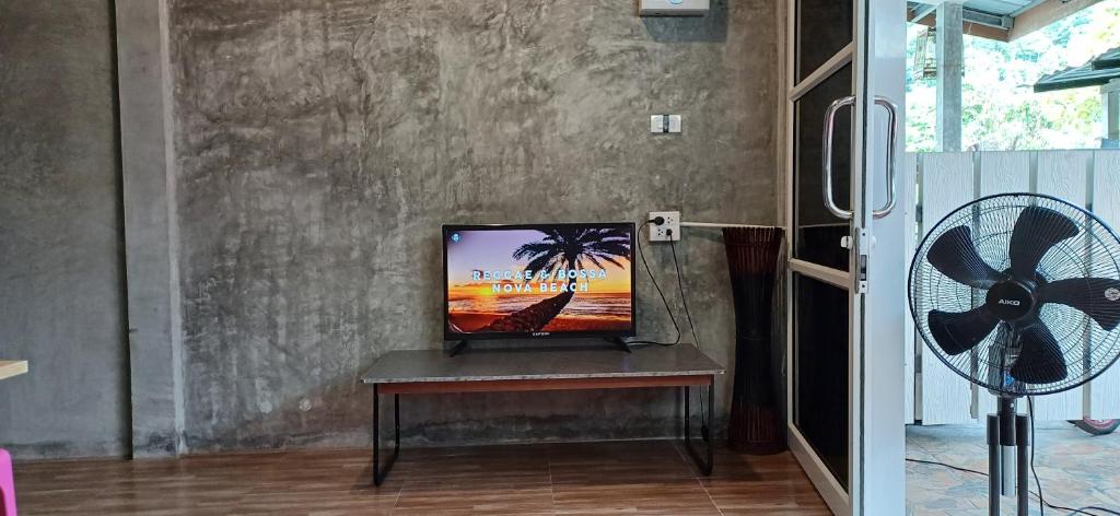 a tv sitting on a table in a room with a fan at Fahad Calm House in Ko Lanta