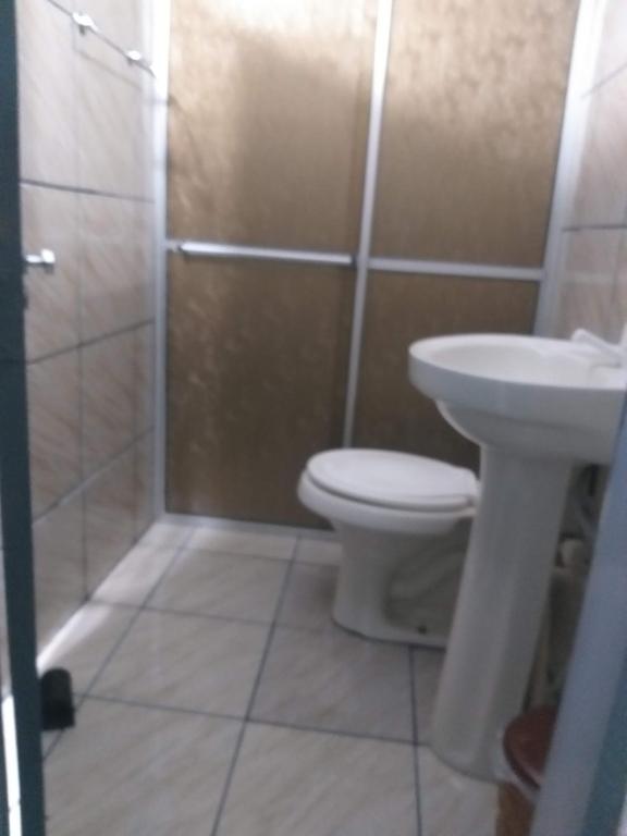 a bathroom with a toilet and a sink and a shower at Kitnet para 4 pessoas in Triunfo
